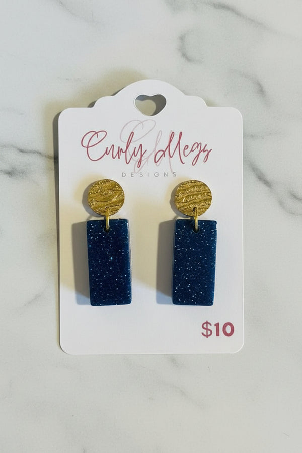 Curly Megs Designs deep blue glitter resin rectangular dangle earrings with hammered gold-tone studs.