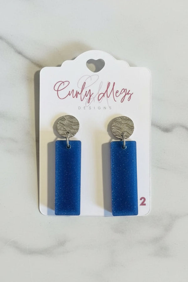 Curly Megs Designs deep blue rectangular resin dangle earrings with textured silver-tone stud tops.