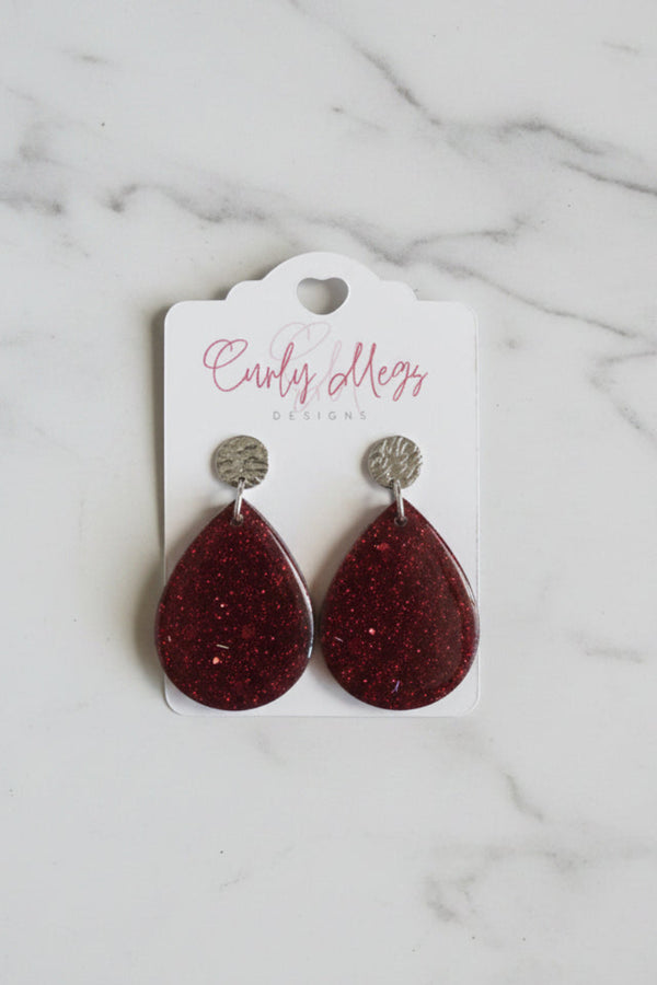 Curly Megs Designs teardrop earrings in deep burgundy resin with glitter, textured silver-tone stud.