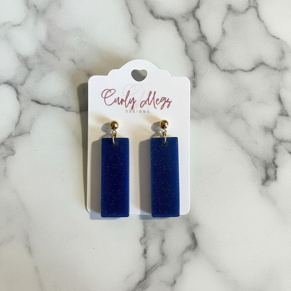 Curly Megs Designs royal blue glitter resin rectangular dangle earrings with gold-tone posts.